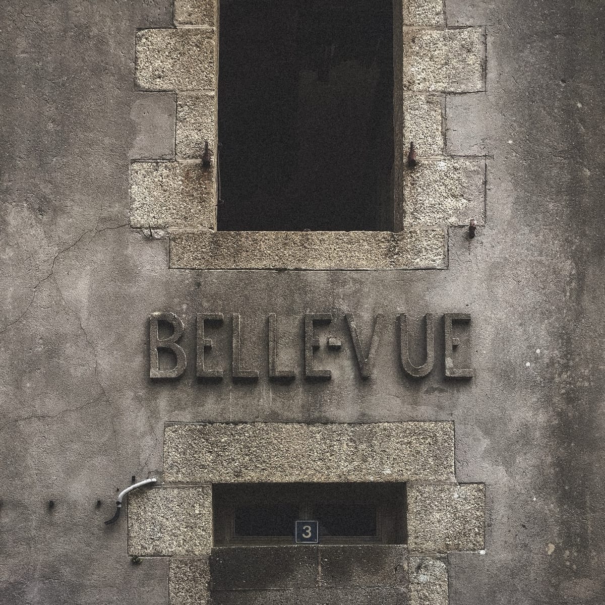 Façade en pierre d’un ancien bâtiment à Roscanvel, avec l’inscription « Bellevue » gravée dans le mur