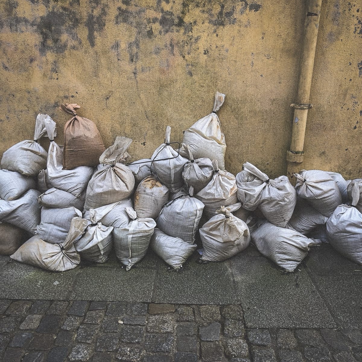 Sacs de sable alignés contre un mur après la crue de l’Odet à Quimper